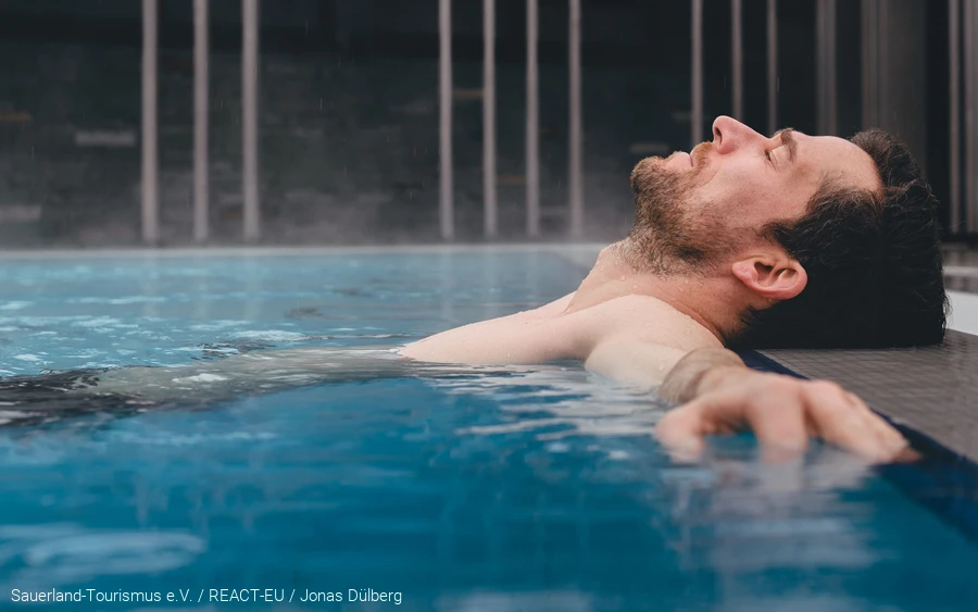 Wellness & Gesundheit - Titelfoto Ein Mann liegt im Thermalbecken von der Börde Therme in Bad Sassendorf. Er entspannt.